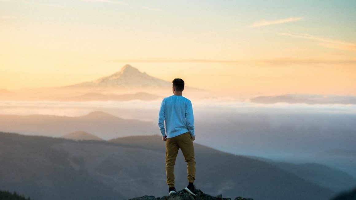 man standing on top of mountain