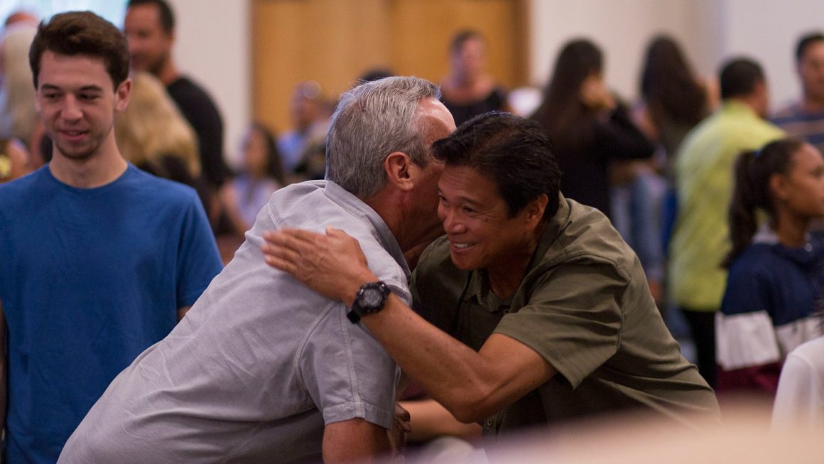 two men hugging on focus photography